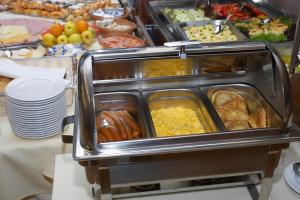 uma linha de buffet com diferentes tipos de alimentos em Hotel Janosik em Liptovský Mikuláš