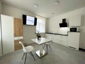 a kitchen with a white table and white chairs at Villa Riverside in Ljubljana