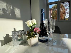 a bottle of wine and a vase with flowers on a table at Villa Riverside in Ljubljana