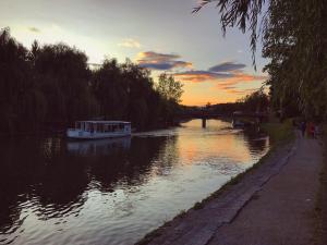 a boat traveling down a river at sunset at Villa Riverside in Ljubljana