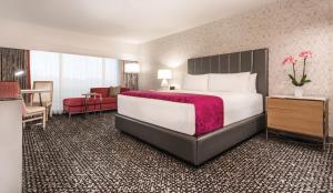 een hotelkamer met een groot bed en een stoel bij Flamingo Las Vegas Hotel & Casino in Las Vegas