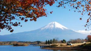 uma montanha coberta de neve à distância com um lago em Kyukamura Fuji em Fujinomiya