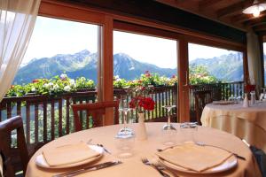 un comedor con 2 mesas y un balcón con montañas en Les Combes, en La Salle