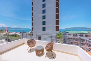 a balcony with two chairs and a view of the water at Dubai Nha Trang Hotel managed by HT in Nha Trang