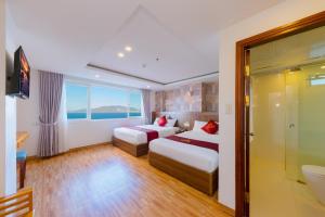 a hotel room with two beds and a bathroom at Dubai Nha Trang Hotel managed by HT in Nha Trang