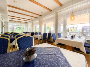 una sala da pranzo con tavoli, sedie e finestre di Hotel-Restaurant Vier Linden a Stade