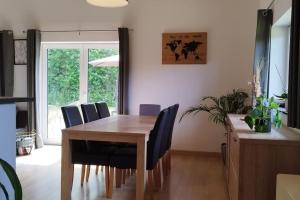 une salle à manger avec une table en bois et des chaises bleues dans l'établissement Le châlet Thomas, à Stavelot