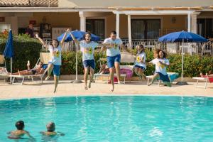 un gruppo di persone che saltano in una piscina di SECRET VILLAGE Budoni a Budoni