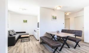 a living room with a table and a couch at Black Forest Hotel Kappel-Grafenhausen in Kappel-Grafenhausen