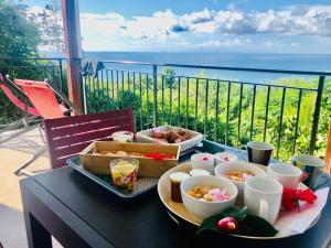 een tafel met een dienblad met eten op een balkon bij Magnifique Villa Bauhinia, Piscine vue mer in Sainte-Luce