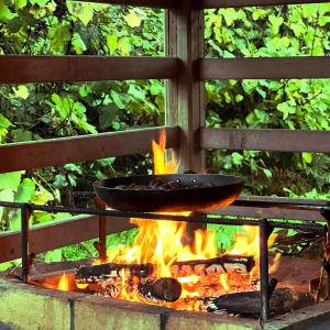 una padella sopra un fuoco su una griglia di Casa do Rio Alva ad Arganil