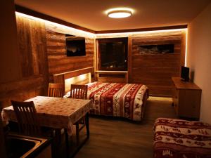 a bedroom with a bed and a table and chairs at Residence Petit Tibet in Breuil-Cervinia