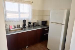 una cucina con frigorifero bianco e lavandino di Riviera del Sur - Apart hotel a Miramar