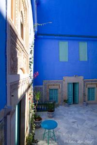 un edificio azul con puertas azules y una mesa en Dar Lekbira Boutique Hôtel, en Sousse