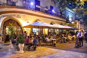 um restaurante com pessoas sentadas em mesas e guarda-sóis em Hotel Colonial Blanco em Santo Domingo