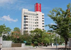 Un bâtiment blanc avec un panneau rouge en haut dans l'établissement Koriyama - Hotel / Vacation STAY 45300, à Koriyama