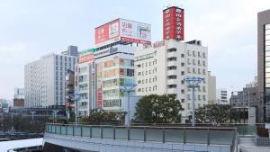 une ligne d'horizon avec de grands bâtiments et un pont dans l'établissement Koriyama - Hotel / Vacation STAY 45300, à Koriyama