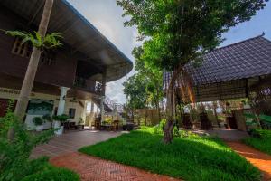 een binnenplaats van een gebouw met een boom ernaast bij The Green Home in Siem Reap