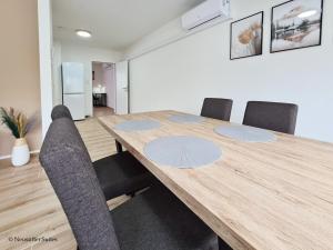 una sala da pranzo con tavolo e sedie in legno di St. Antoni Suite 5 a Eisenstadt