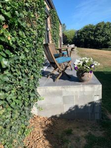 a bench sitting on a porch next to a plant at Lovely 1-bedroom appartement Le Joyau with indoor pool and sauna in Lasne