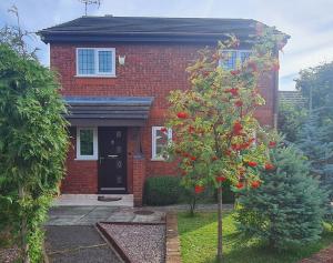 una casa di mattoni rossi con un albero di fronte di Spacious, 5 bed house for 9 in Chester a Chester