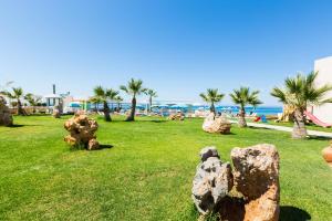 a park with rocks in the grass near the beach at Theo Star Beach Hotel in Malia