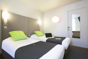 een hotelkamer met 2 bedden en een laptop erop bij Campanile Paris Ouest - Pont de Suresnes in Suresnes