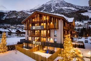 um edifício na neve com uma árvore de Natal em Nira Mountain Resort Futura em Valdidentro