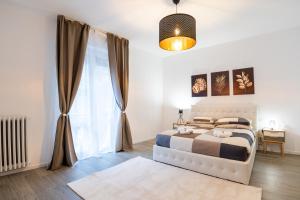 um quarto com uma cama e uma grande janela em Nord Milano Luxury Apartments em Bresso