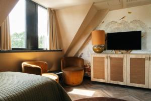 Cette chambre comprend un lit et une télévision à écran plat. dans l'établissement Van der Valk Hotel Apeldoorn - de Cantharel, à Apeldoorn