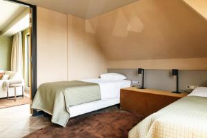 - une chambre avec deux lits et une chaise dans l'établissement Van der Valk Hotel Apeldoorn - de Cantharel, à Apeldoorn