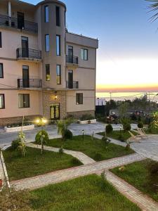 a large apartment building with a park in front of it at Green Yard Hotel in Batumi