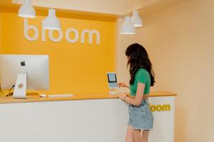 a woman standing at a counter with a laptop at Bloom Hotel - Sector 62 in Noida