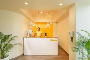 a man standing at a reception desk in a office at Bloom Hotel - Sector 62 in Noida