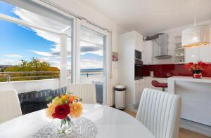 a kitchen and dining room with a table with flowers on it at Marina Lux Split in Split