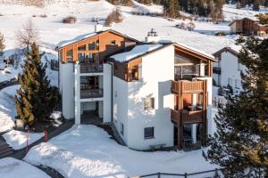 una casa en invierno con nieve en el suelo en Casa Collina 5i-02, en Flims