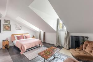 Schlafzimmer im Dachgeschoss mit einem Bett und einem Sofa in der Unterkunft ROOM SAUVAGE in Vincennes