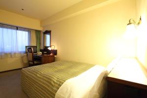 A bed or beds in a room at Hirosaki Park Hotel