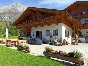 uma casa nas montanhas com flores na frente em Gästehaus Gschwandtner em Mühlbach am Hochkönig