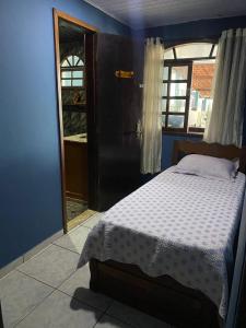 a bedroom with a bed and a door with a window at Pé nas trilhas in Rio de Janeiro