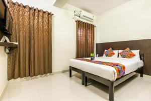 een slaapkamer met een bed en een raam bij FabHotel RMS Comforts - Nr Yeshwantpur Railway Station in Bangalore