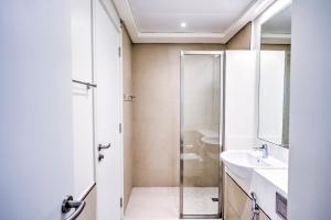 La salle de bains est pourvue d'une douche et d'un lavabo. dans l'établissement Expo Village Serviced Apartments, à Dubaï