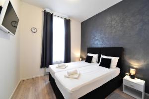 una camera da letto con un grande letto con lenzuola bianche di Virtus Apartments and Rooms with Free Private Parking a Zagabria