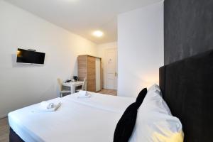 una camera con letto e TV a parete di Virtus Apartments and Rooms with Free Private Parking a Zagabria