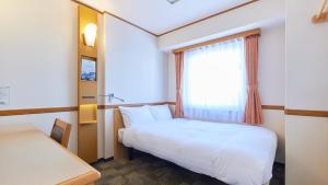 茅崎市Toyoko Inn Shonan Chigasaki eki Kita guchi的小房间设有床和窗户