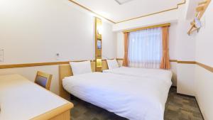 茅崎市Toyoko Inn Shonan Chigasaki eki Kita guchi的客房设有两张床和窗户。