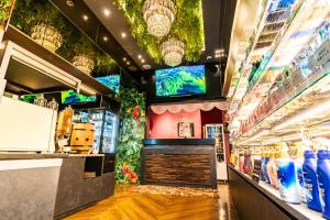 une allée de magasins avec un bar et des vases en exposition dans l'établissement Petit Bali Forest Shinjuku Sanchōme, à Tokyo