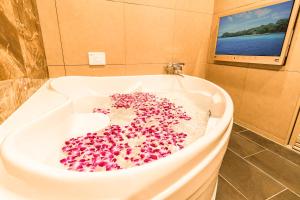 une baignoire remplie de beaucoup de perles roses dans l'établissement Petit Bali Forest Shinjuku Sanchōme, à Tokyo