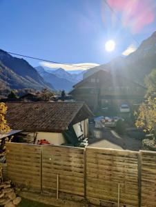 una recinzione di fronte a una casa con montagne sullo sfondo di Hubel Apartment 14 a Wilderswil