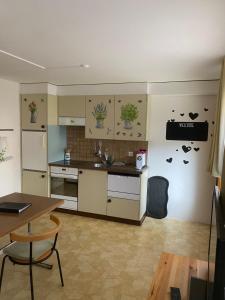 cocina con armarios blancos, mesa y mesa en Ferienwohnung Allalinblick, en Saas-Fee